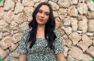 Chloe van Niekerk glimlag voor ’n grys klipmuur